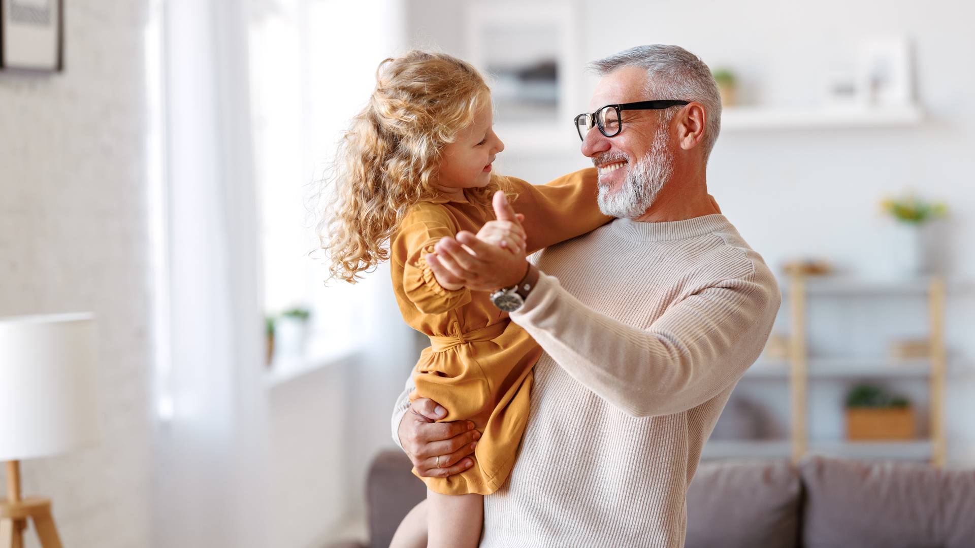 A grandfather carries his granddaughter
