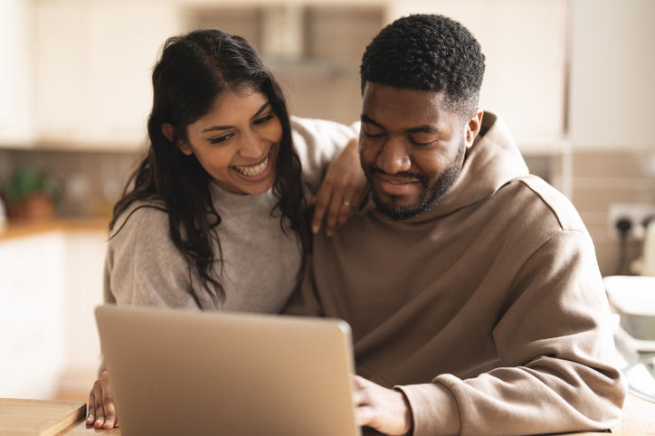happy couple looking at a laptop